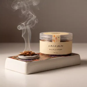 عبوة بخور عنفر سوداني أصيل 100 جرام، معروض بجانب مبخرة نحاسية (مجمرة) يتصاعد منها دخان البخور العطري.