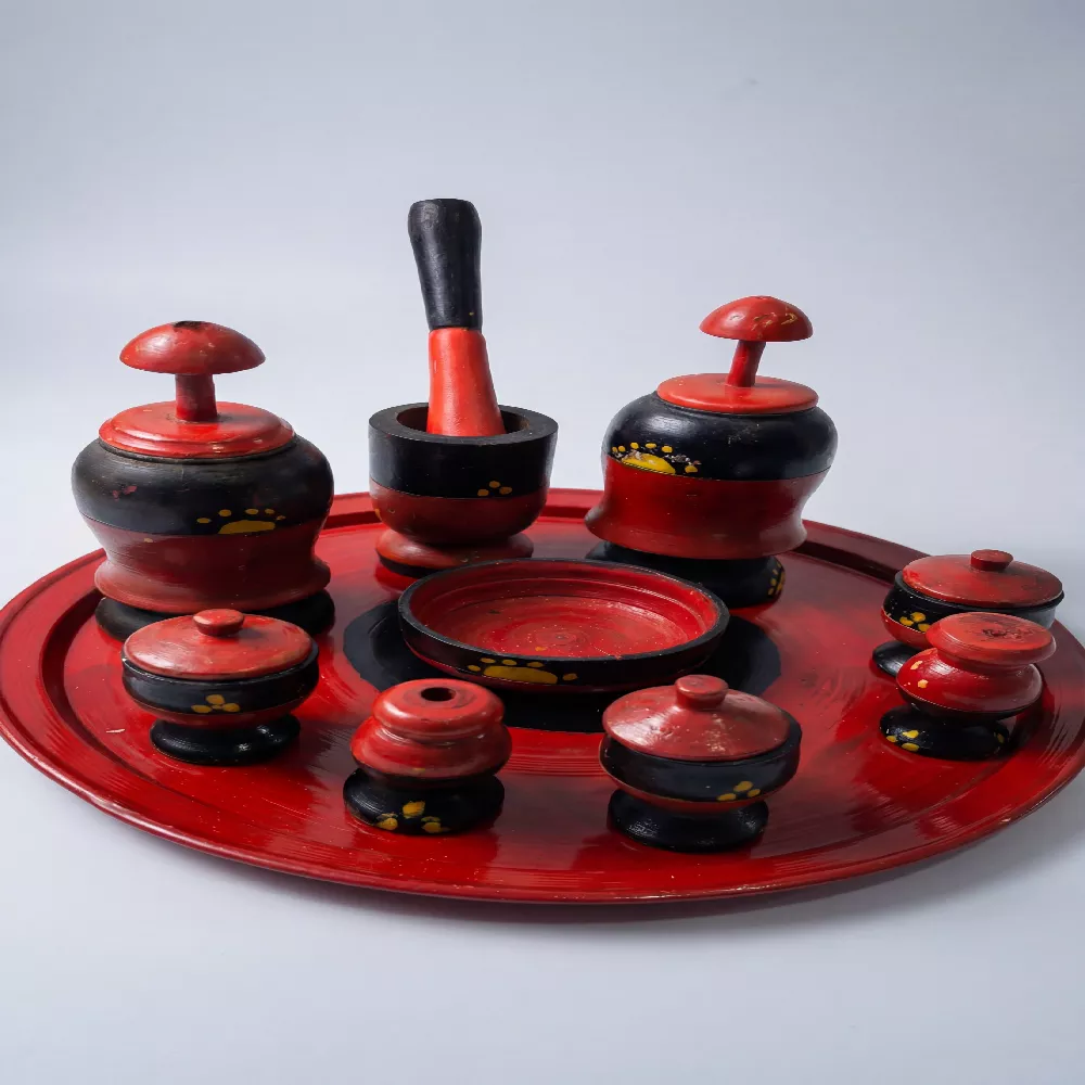 صينية جرتق سودانية تقليدية من الخشب المنقوش باللونين الأحمر والأسود، تضم مبخر وعلب بخور وعطور تراثية بتصميم يدوي فخم